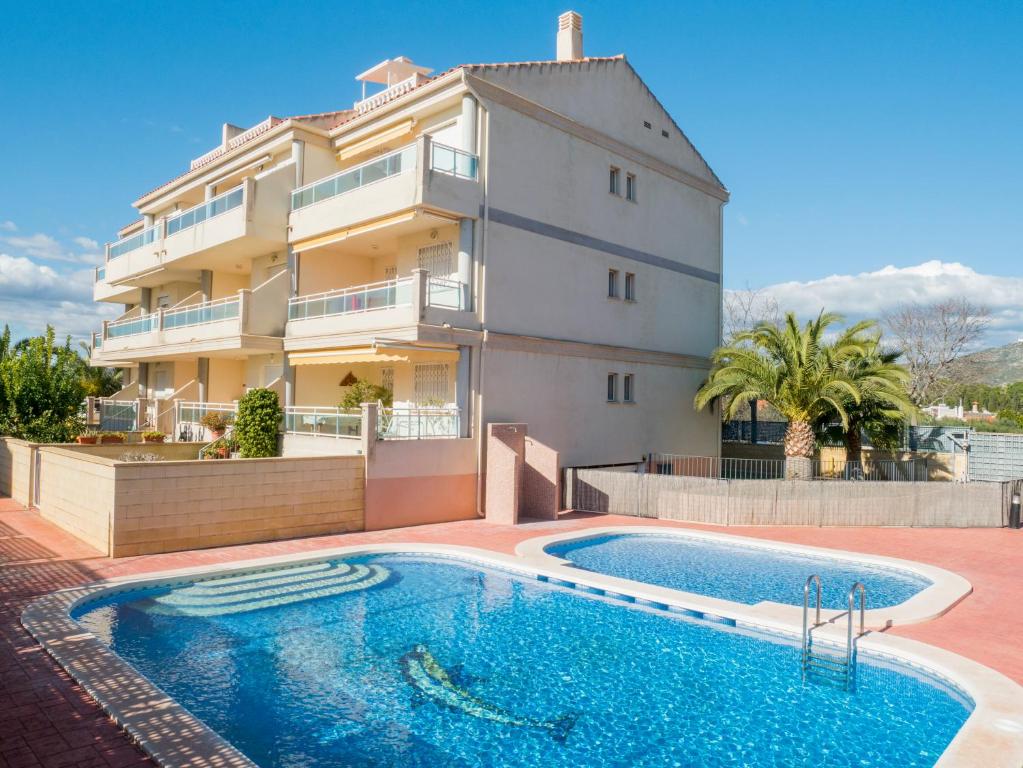 a house with a swimming pool in front of a building at Apartamentos Doña Maria in Alcossebre