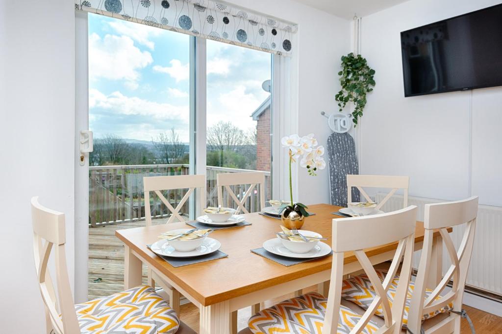 uma sala de jantar com mesa e cadeiras e uma grande janela em Pleasant Stay in Swansea - TV in Every Bedroom! em Swansea