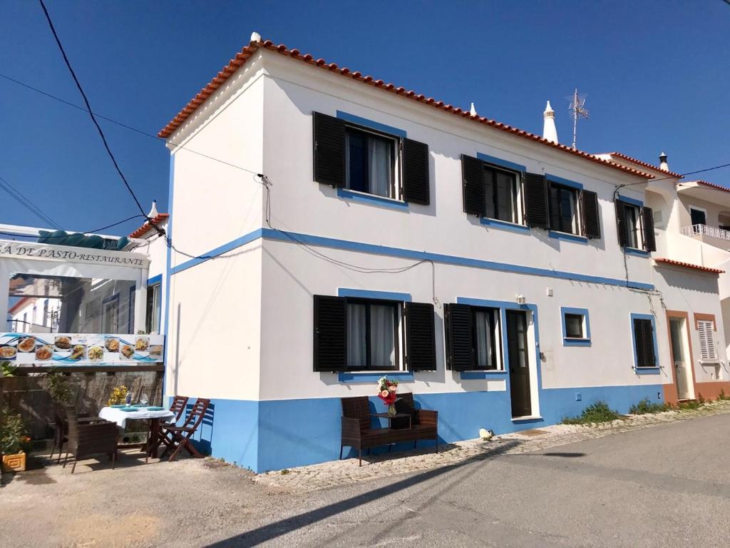 ein weißes und blaues Haus mit schwarzen Fenstern in der Unterkunft House located in opposite of beach! in Lagoa