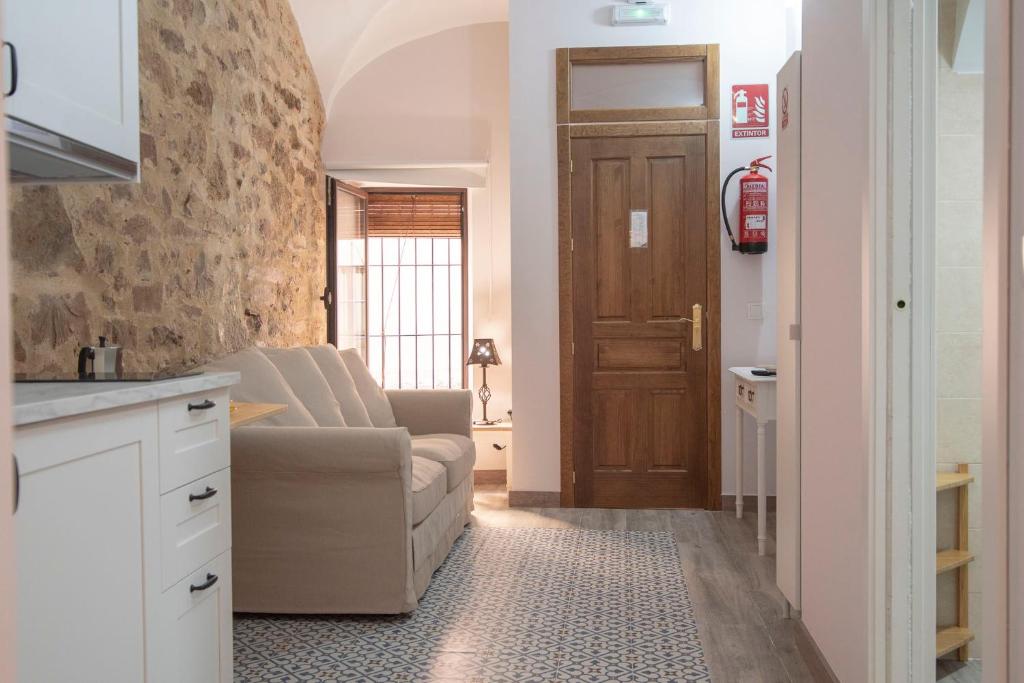 sala de estar con sofá y cocina con puerta en Apartamento nuevo Casco Antiguo AT Postigo 20, en Cáceres