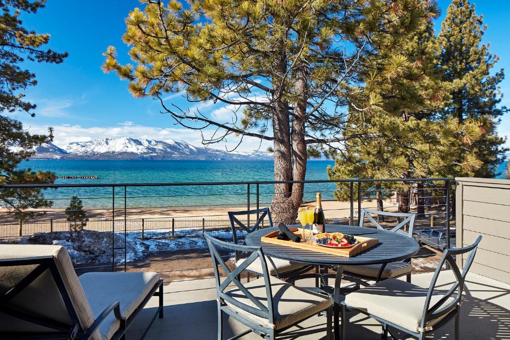 a table and chairs on a patio with a view of the beach at The Landing Resort and Spa in South Lake Tahoe