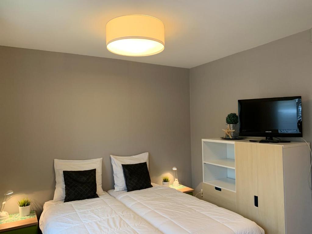 デ・コーフにあるTexelheerlijk 2のベッドルーム1室(ベッド2台、薄型テレビ付)