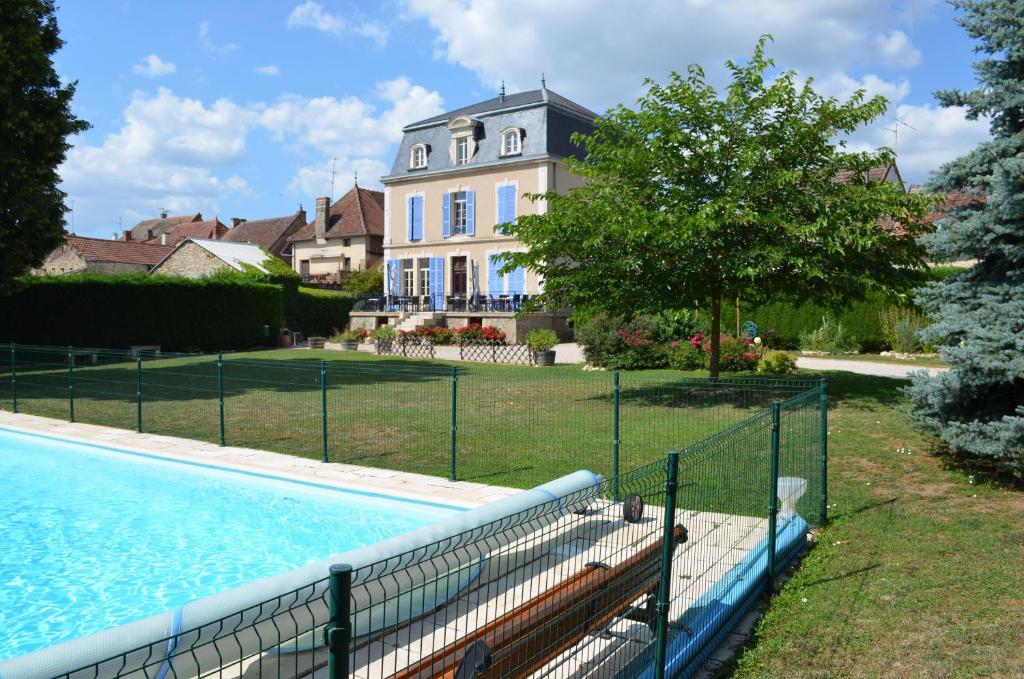 uma casa com piscina em frente a uma casa em Hôtel Restaurant du Cheval Blanc em Saint-Boil