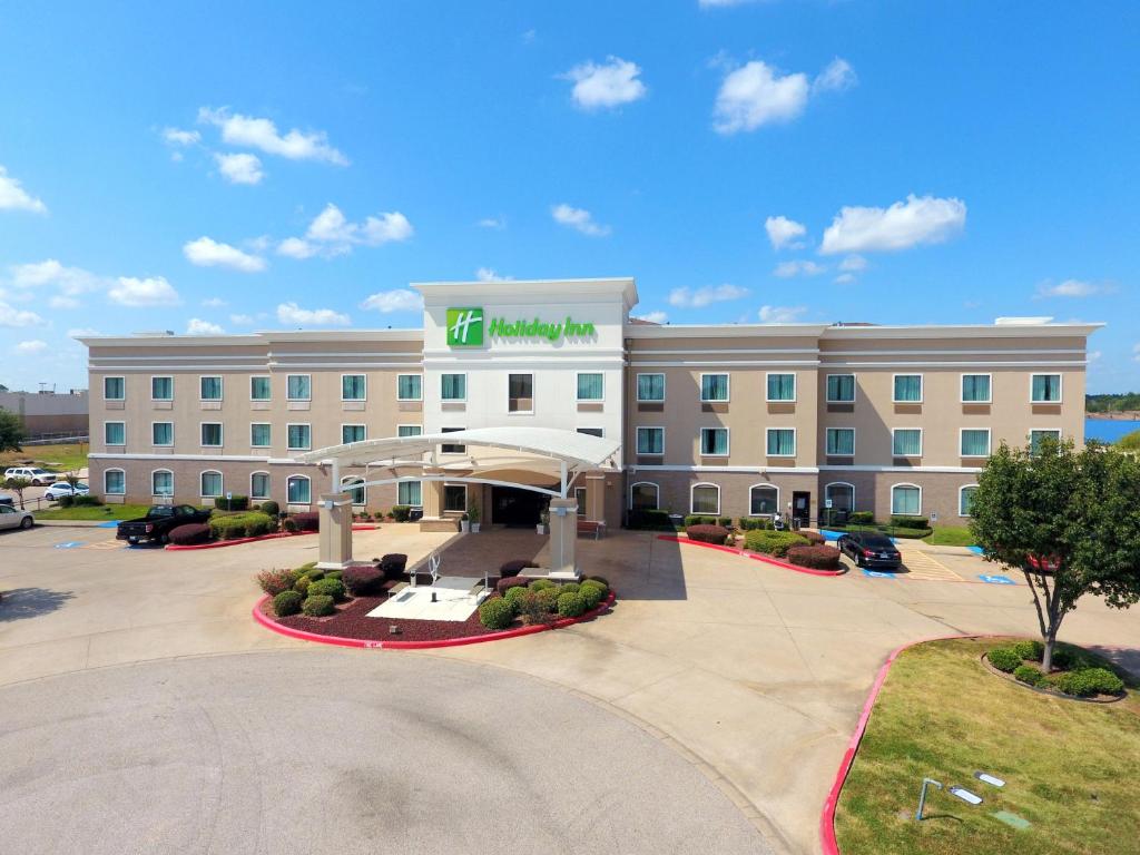 ein Hotelgebäude mit einem Parkplatz davor in der Unterkunft Holiday Inn Longview - North, an IHG Hotel in Longview