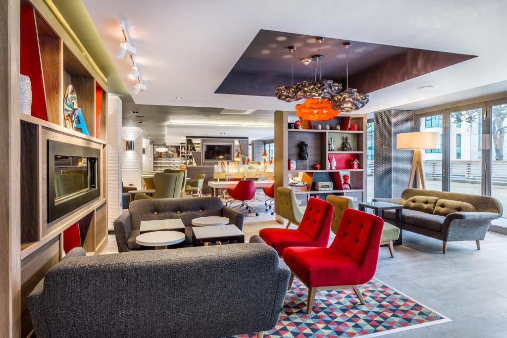 a lobby with couches and chairs and a table at Holiday Inn London Watford Junction, an IHG Hotel in Watford