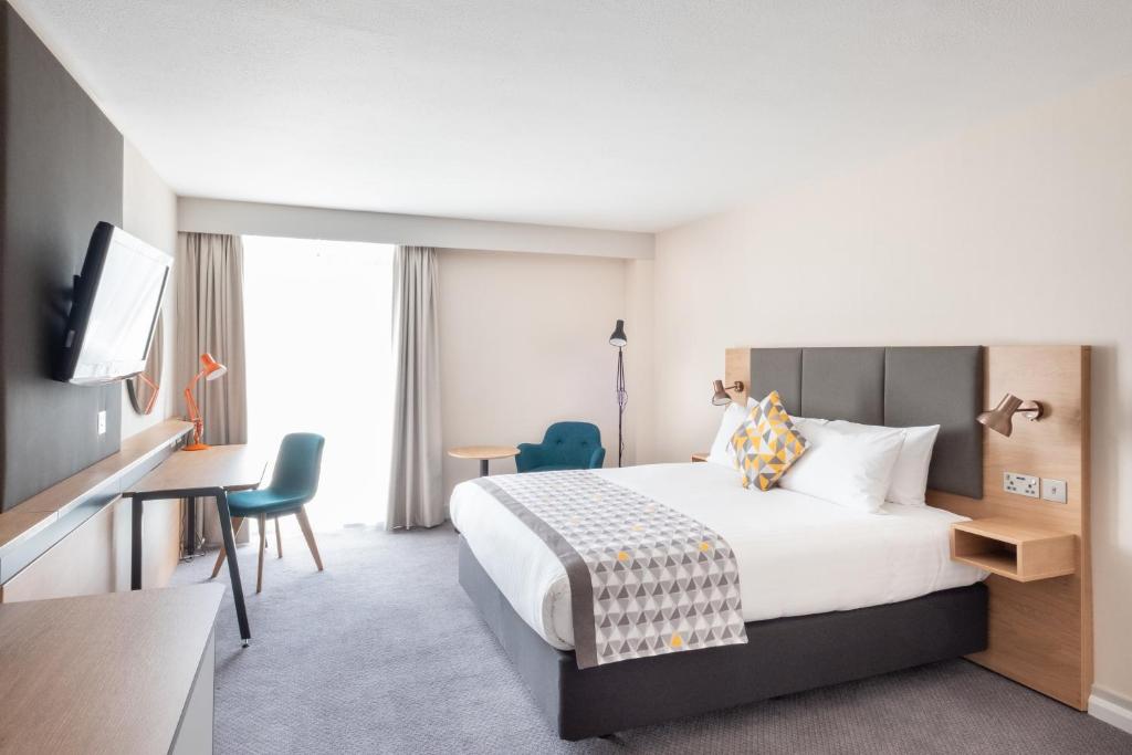 a hotel room with a bed and a desk and a tv at Holiday Inn Leicester City, an IHG Hotel in Leicester