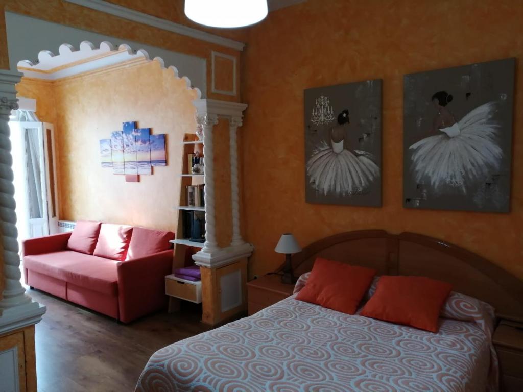 a bedroom with a bed and a red chair at Hospedaje Menendez Pelayo in Santander