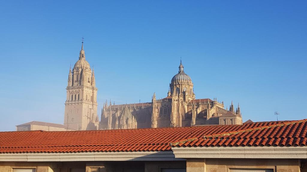 a large building with two towers and red tile roofs at LOFT ESTUDIO CATEDRAL CASA LIS in Salamanca