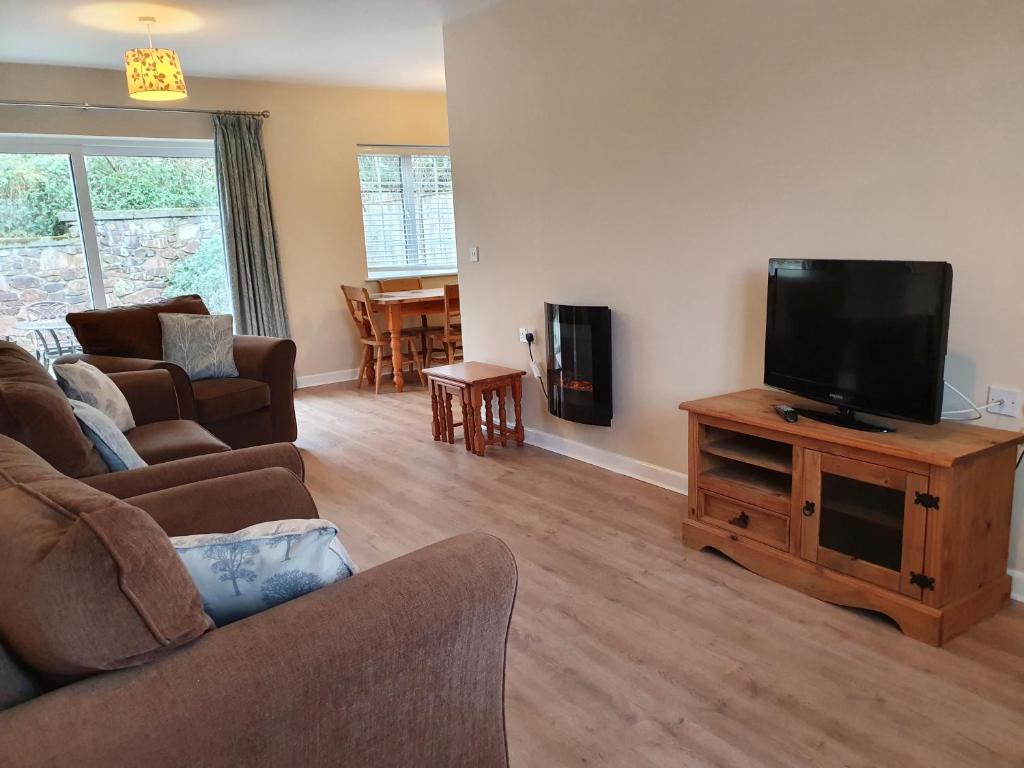 a living room with a couch and a flat screen tv at Tehidy Holiday Park in Illogan