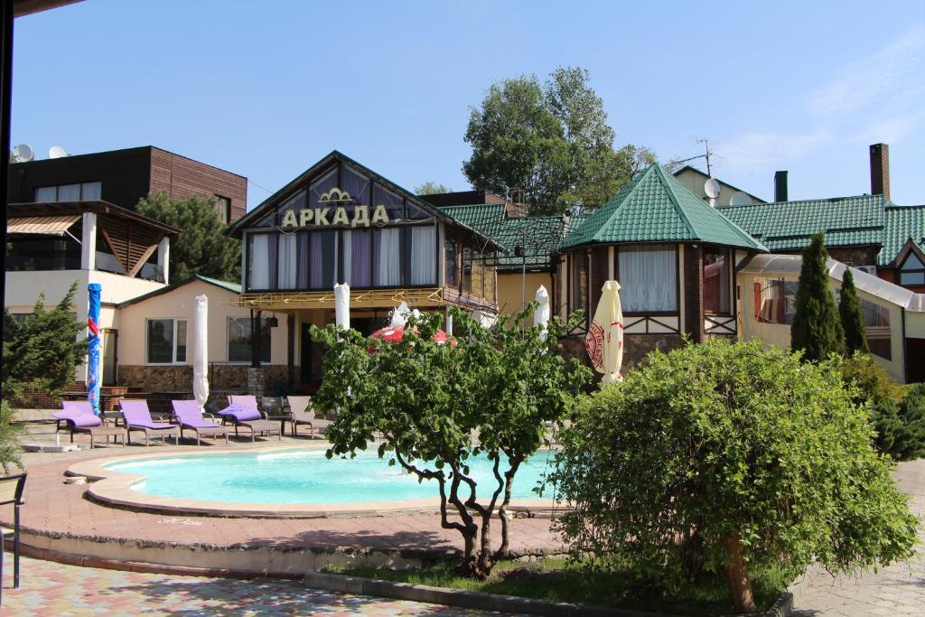 a hotel with a swimming pool in front of a building at Arkada Hotel Kharkiv in Kharkiv