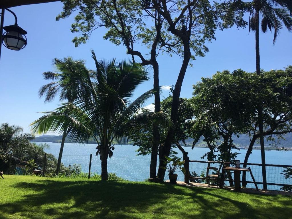 Blick auf das Wasser von einem Resort mit Palmen in der Unterkunft Gidu Ilhabela in Ilhabela