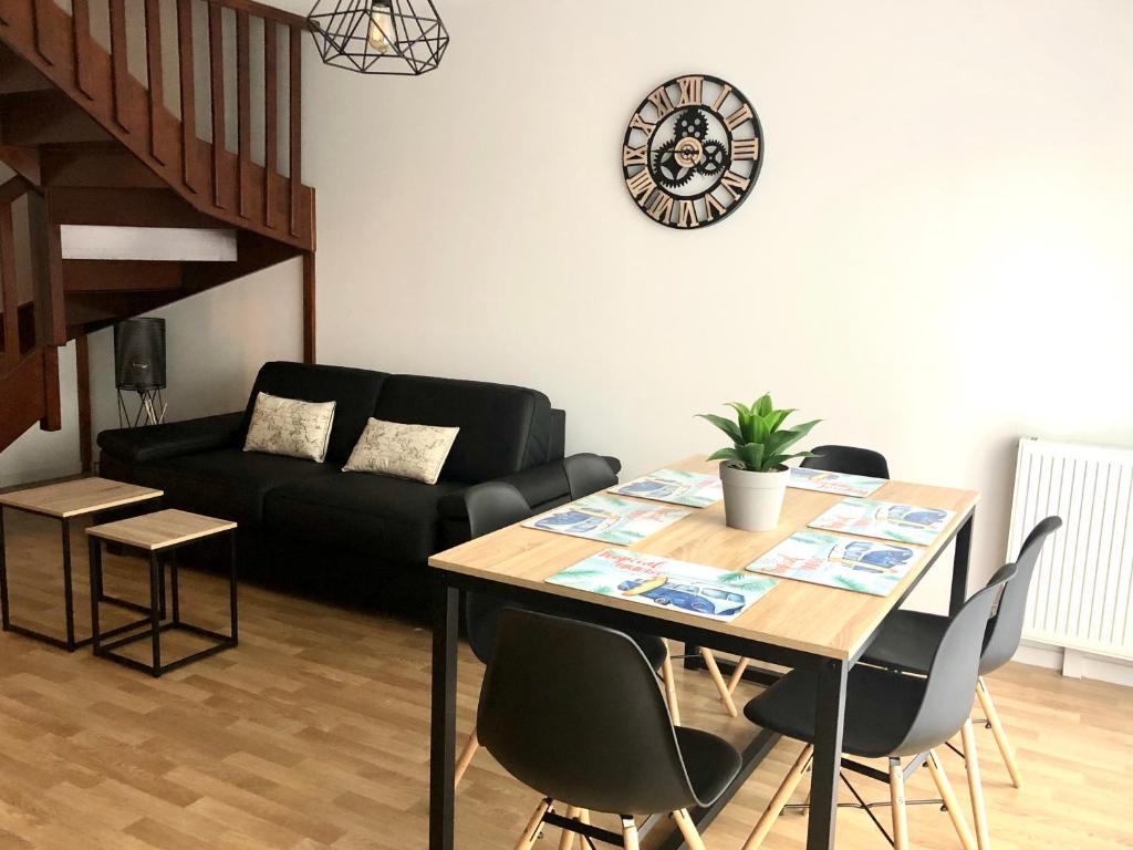 a living room with a table and a black couch at happiness Disney in Saint-Germain-sur-Morin