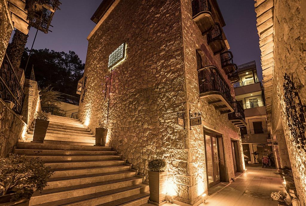 a stone building with stairs on a street at night at Kazdaglari Karye Müze Hotel in Kucukkuyu