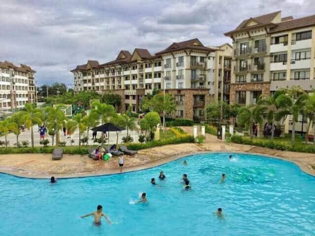 un grupo de personas en una piscina en un complejo en One oasis A10 3mins walk SM Mall,free pool - wifi, en Davao City