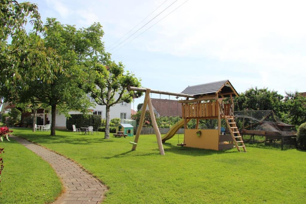 um parque infantil com um escorrega e uma estrutura de jogos em Ferienwohnung Ingrid em Kressbronn am Bodensee
