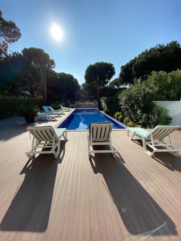 a deck with two lounge chairs and a swimming pool at Amora Villa - Vilamoura in Vilamoura