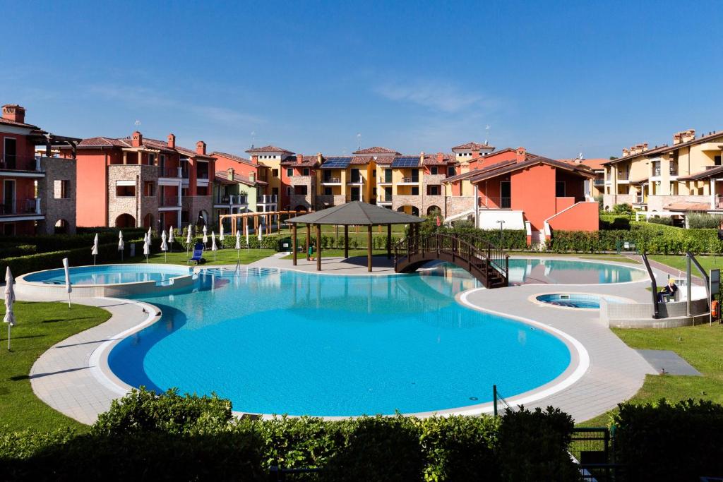 une grande piscine dans un parc avec des bâtiments dans l'établissement Appartamento Corina, à Sirmione