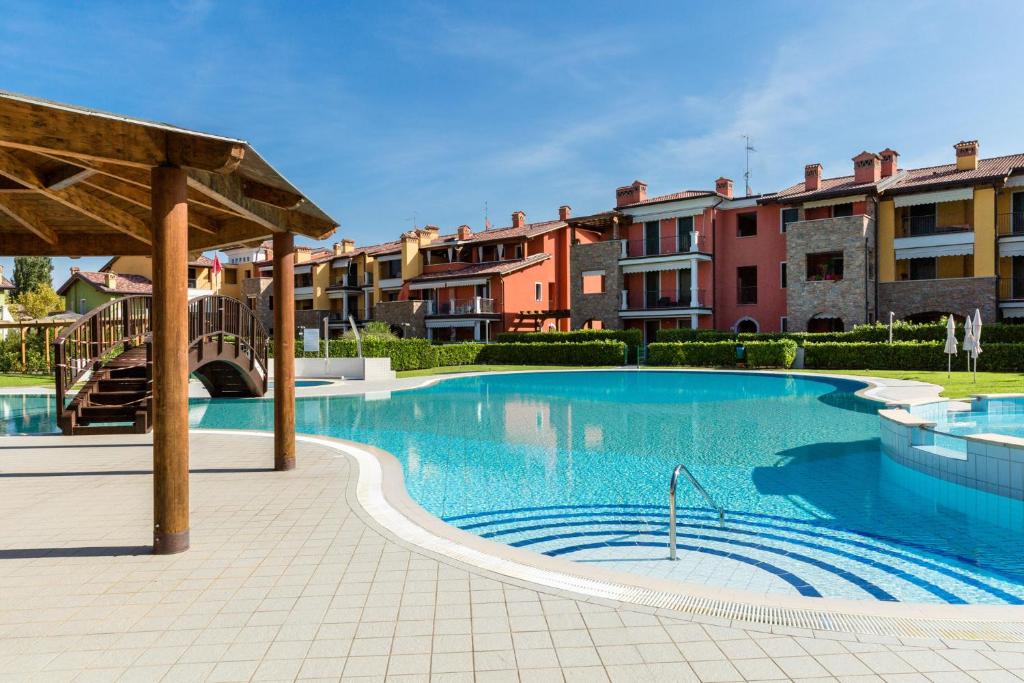 Una gran piscina con edificios al fondo. en Appartamento Corina, en Sirmione