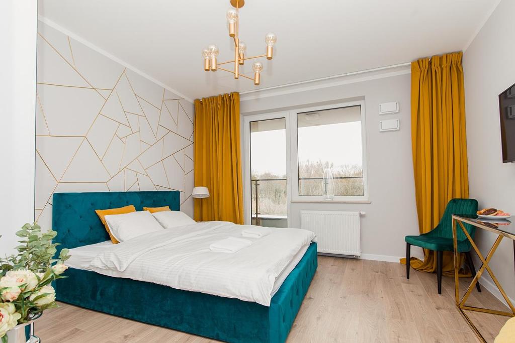 ein Schlafzimmer mit einem blauen Bett und gelben Vorhängen in der Unterkunft Warsaw To Be - Golden Apartment in Warschau