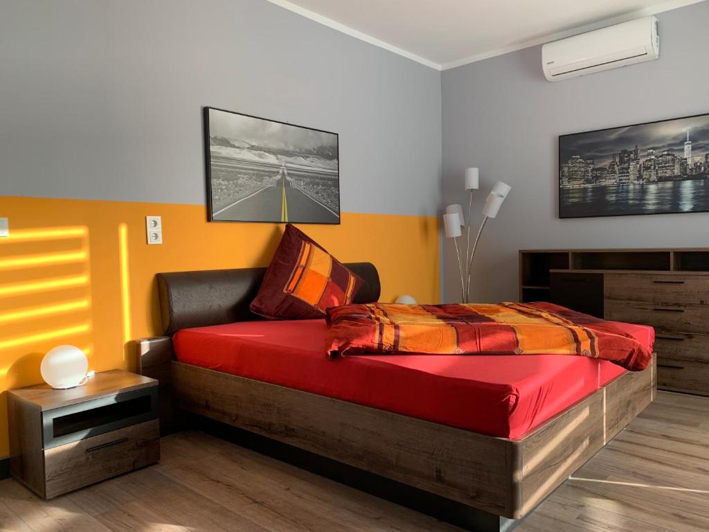 a bedroom with a bed with a red comforter at Stadtvilla Intzeplatz - Apartment Föhr in Remscheid