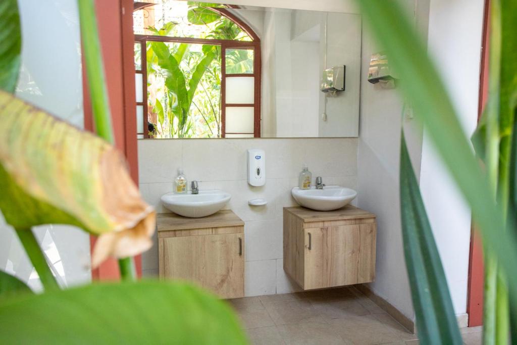a bathroom with two sinks and a mirror at La Vaina Cali in Cali