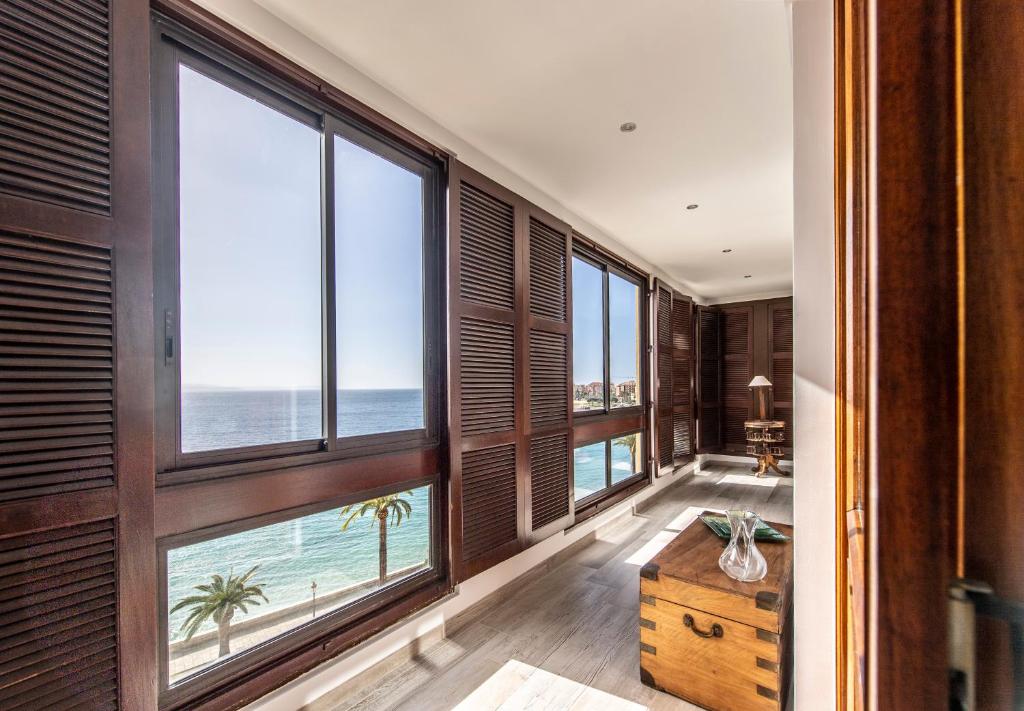 um quarto com grandes janelas com vista para o mar em Appartement Front de Mer Hyper Centre em Ajaccio