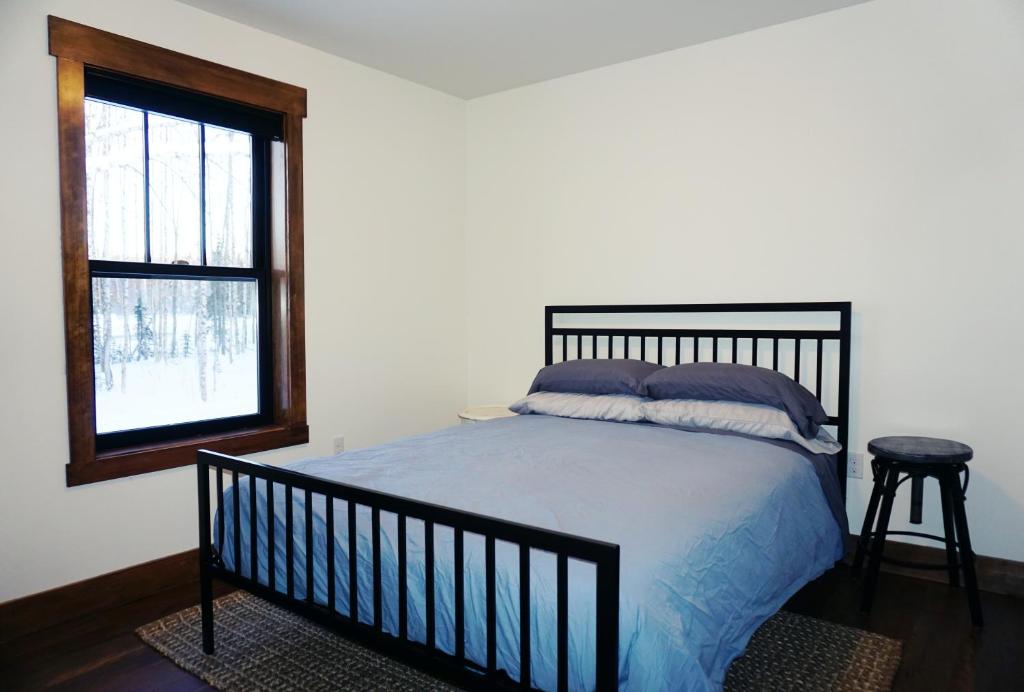 Un dormitorio con una cama grande y una ventana en Silver Birch Vacation Rental, en Talkeetna