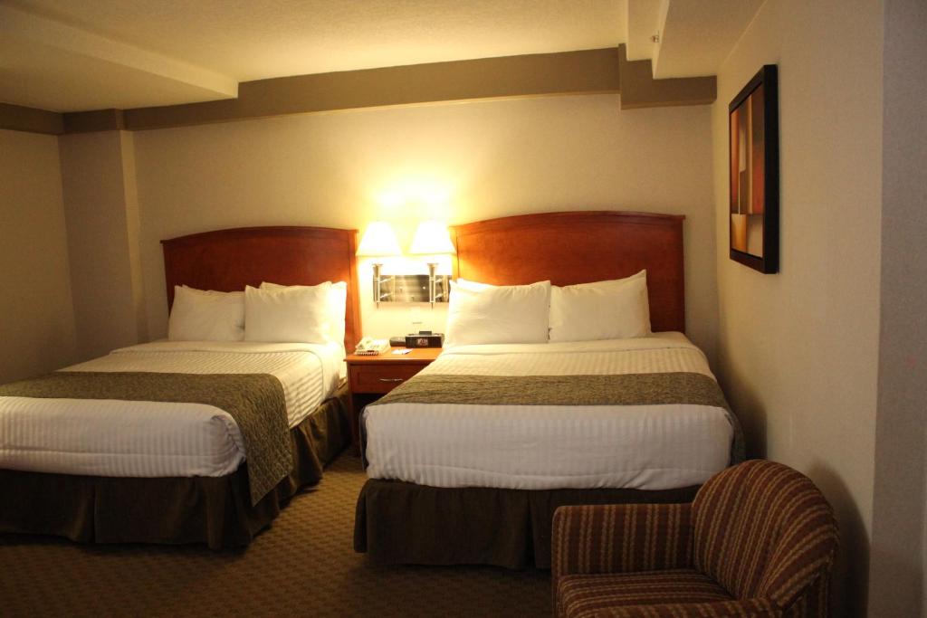 Postel nebo postele na pokoji v ubytování Ramada by Wyndham Edmonton South