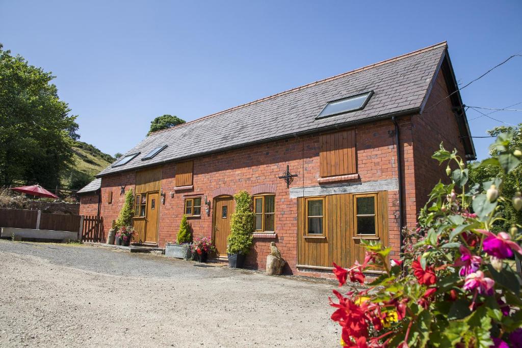 a red brick building with windows and flowers at Finest Retreats - 2 Bed Llangollen Cottage - Sleeps 4 in Llangollen