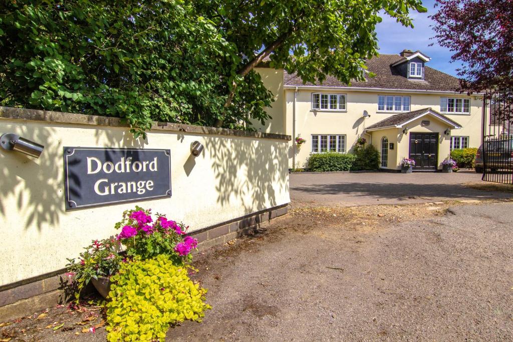 a sign in front of a house with a doorman garage at Dodford Grange in Daventry