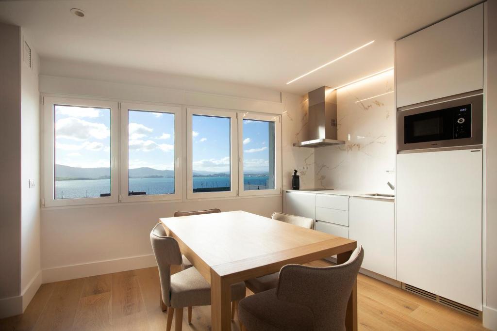 a kitchen with a table and chairs in a room at Apartamentos Reina Victoria in Santander