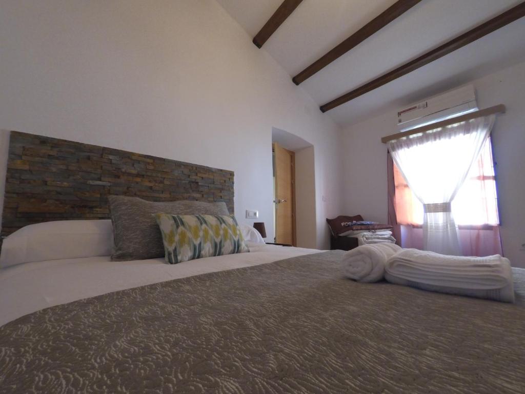ein Schlafzimmer mit einem großen Bett und einem Fenster in der Unterkunft Apartamentos Fuente Nueva II in Cáceres
