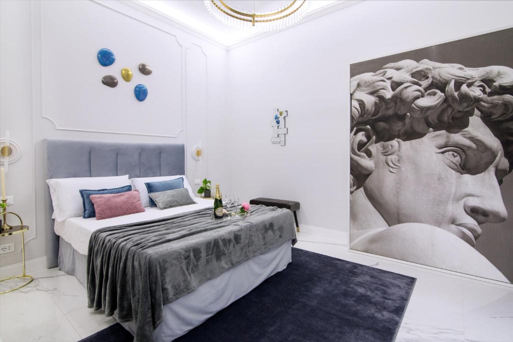 sypialnia z łóżkiem z obrazem na ścianie w obiekcie Roma Deluxe Apartments w Rzymie