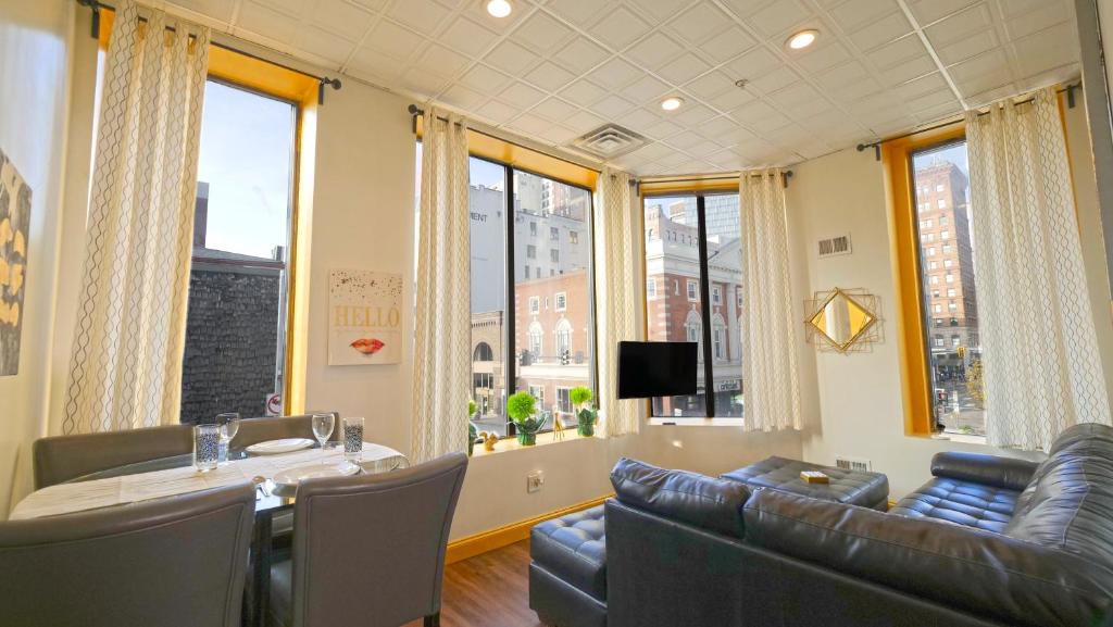 a living room with a table and a couch and windows at Stay Pittsburgh in Pittsburgh