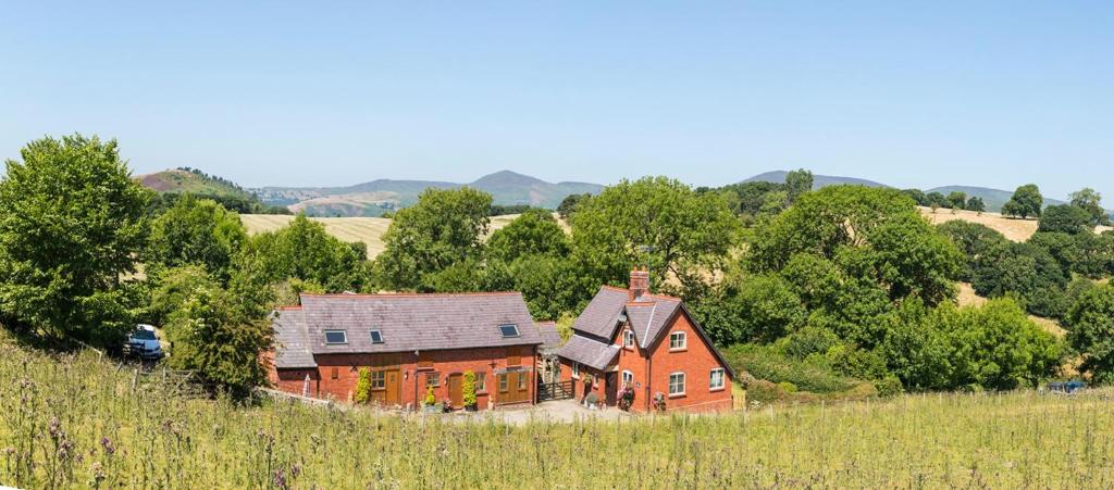 uma grande casa vermelha no meio de um campo em Finest Retreats - 1 Bed Llangollen Cottage - Sleeps 2 em Llangollen