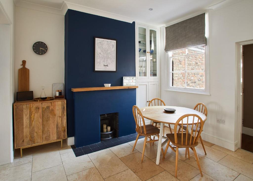 une salle à manger avec une table et un mur bleu dans l'établissement Best Stays York - Alma York, à York