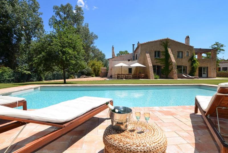 a swimming pool with a table and chairs next to a house at Club Villamar - Maria Saris in Monells