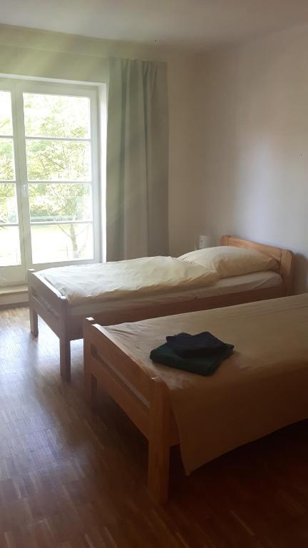 two beds in a room with a window at ruhiges Zimmer in Pankow in Berlin