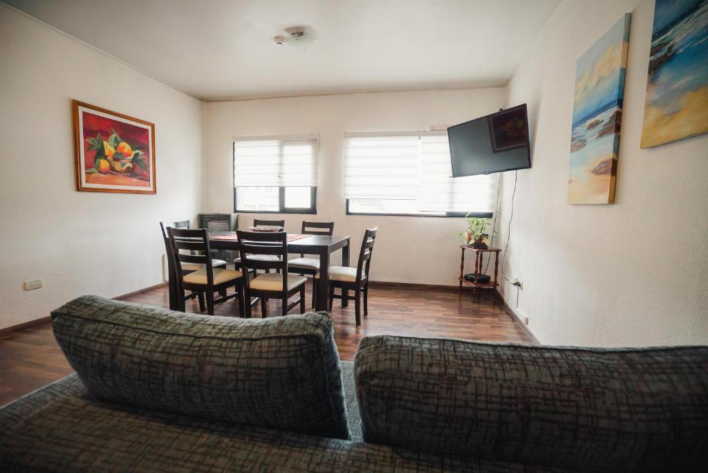 a living room with a table and chairs and a television at Departamento Ideal in Ushuaia