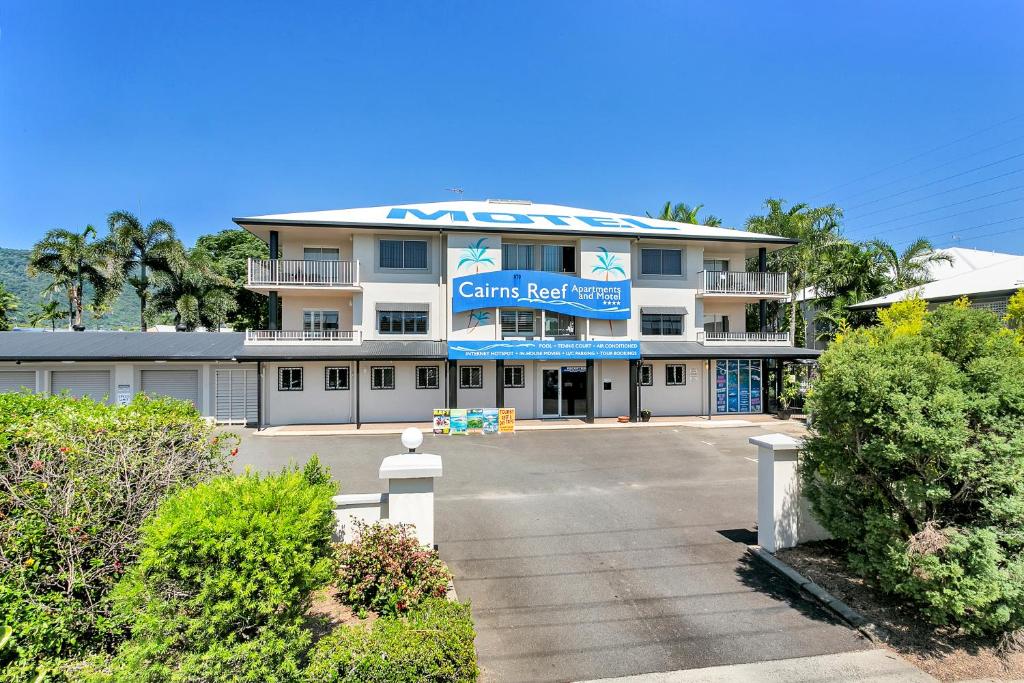 Cairns Reef Apartments & Motel في كيرنز: مبنى عليه لافته مكتوب عليها منتجع الصين الشعاب المرجانية