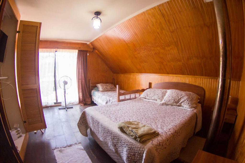 um quarto com duas camas e uma janela em Hostal Helios em Los Ángeles