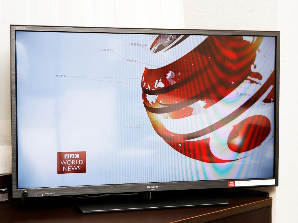 a flat screen tv sitting on a wooden stand at APA Hotel Tennoji Ekimae in Osaka
