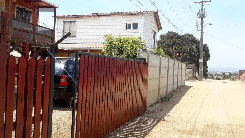 un coche estacionado junto a una valla al lado de una casa en "ERyMAR" CASA PARA FAMILIAS A PASOS DE CALETA HORCON, en Puchuncaví