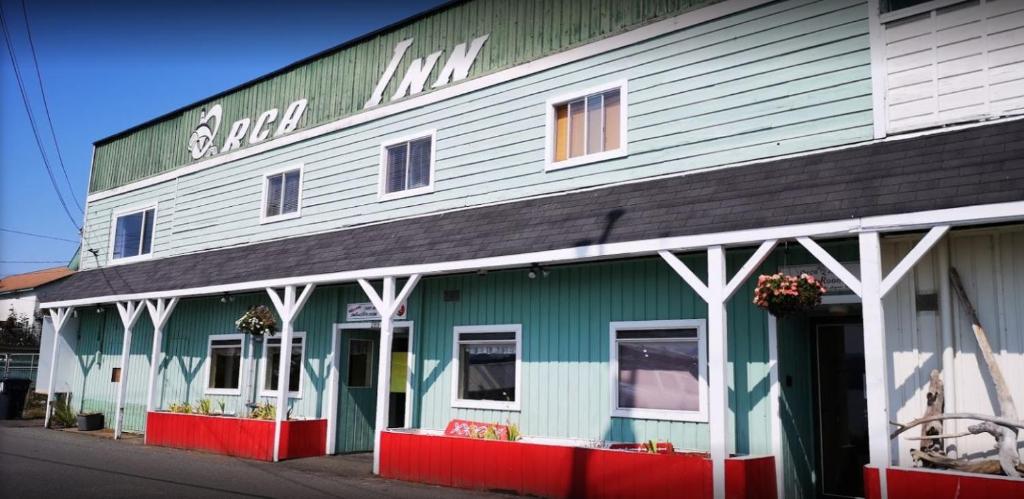 a green and white building with a sign on it at Orca Inn in Alert Bay