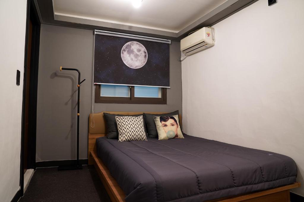 a bedroom with a bed in a room with the moon at Apollo Guesthouse in Seoul