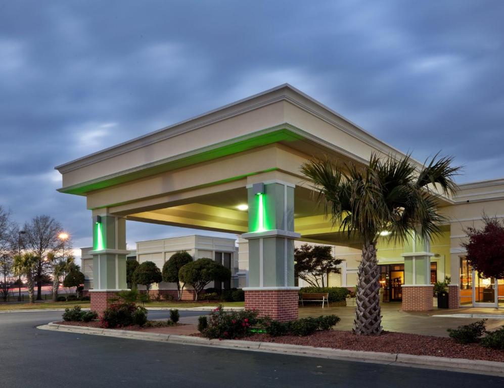 a front view of a hotel with a palm tree at Holiday Inn Lumberton, an IHG Hotel in Lumberton