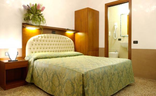 a hotel room with a bed and a bathroom at Atlantide Hotel in Venice