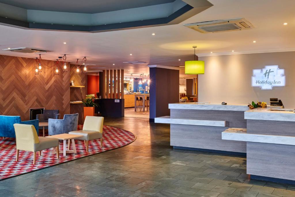 a lobby of a hotel with chairs and a bar at Holiday Inn Leeds Garforth, an IHG Hotel in Garforth