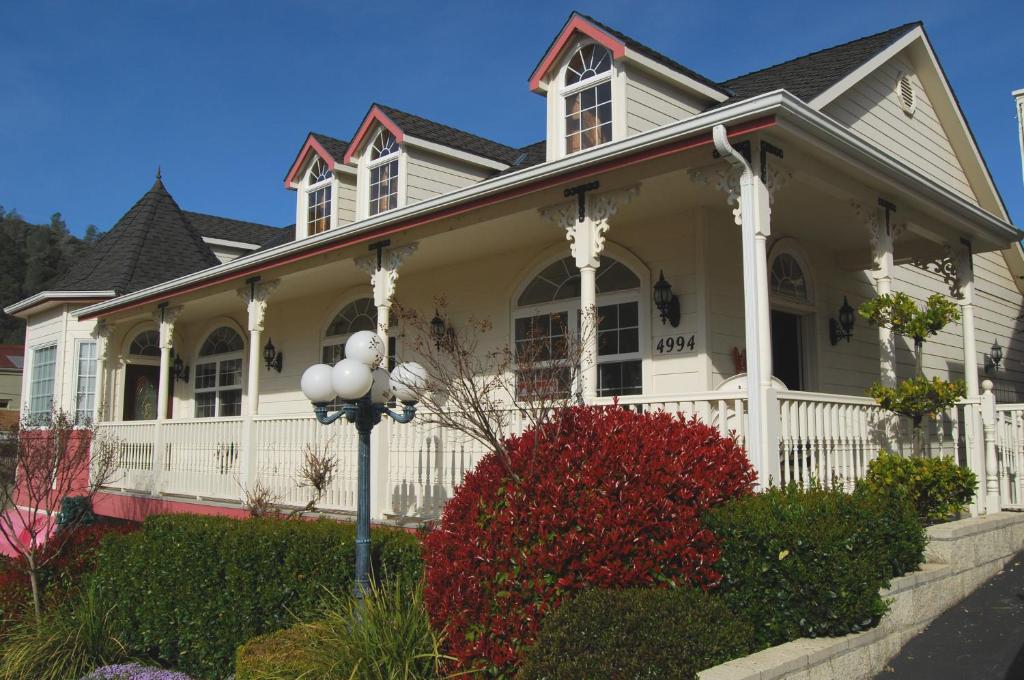 a white house with a white fence at 5th Street Inn in Mariposa