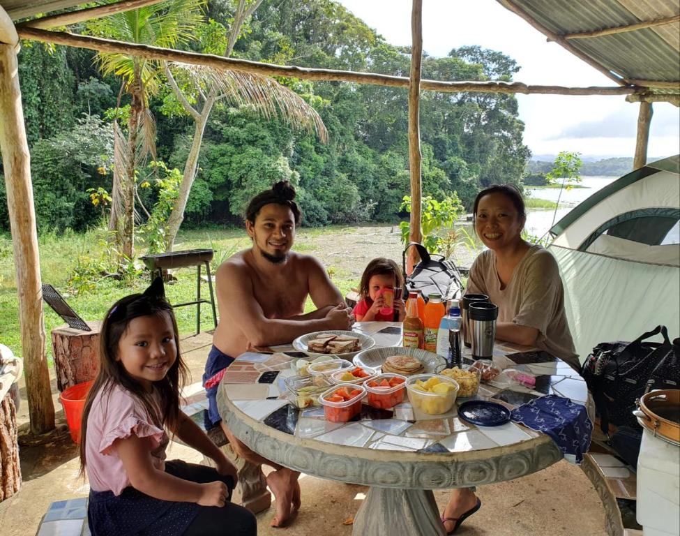 een groep mensen die rond een tafel zitten met eten bij Jungle Eco Reserve in Colón